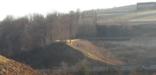 A view of the South and North abutments of the South Fork Dam.  The Visitor Center, Unger House, and Spring House are visible in the background.  As is visible, a spur railroad line connects coal trains with the main line of the railroad.