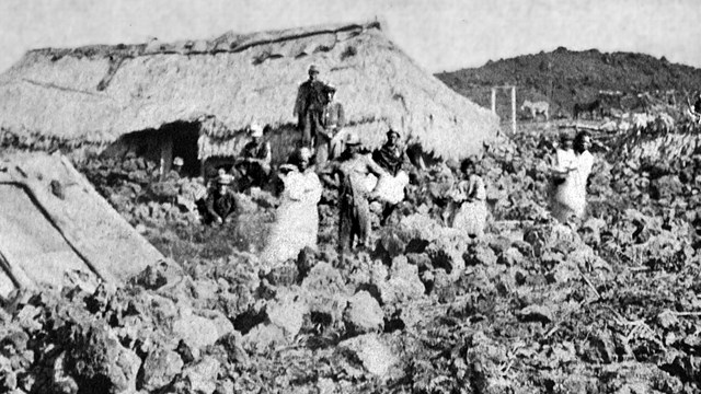 Black and white photograph of devastated houses in a field of rubble