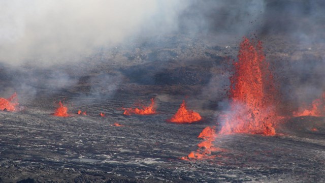 A series of volcanic vents erupting from a crater floor. 