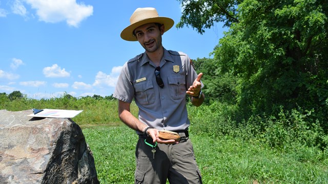 A park ranger gives a presentation outside. 