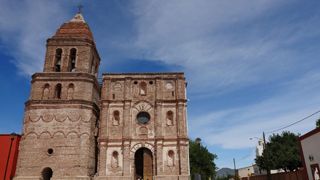 A stone church with bell tower along a village street