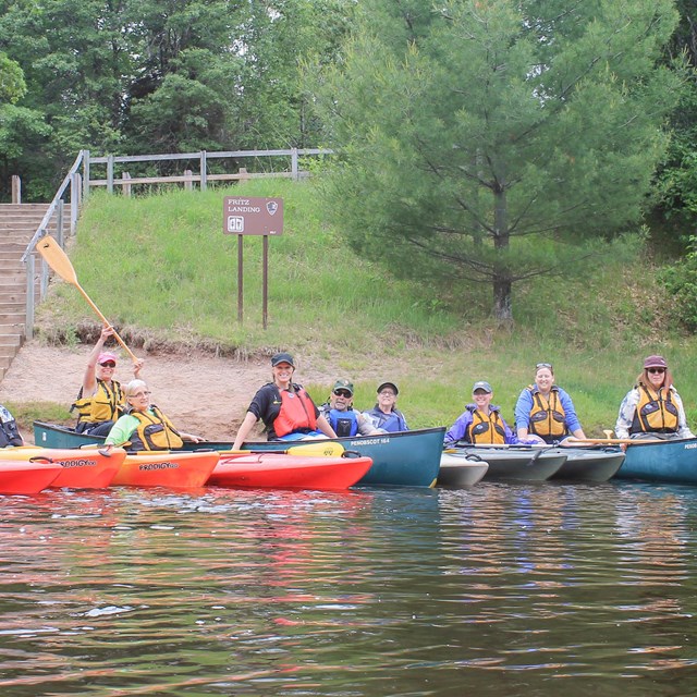 Group of women veterans in a line of kayaks on a river