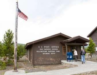 One-story brown building with blue mail box next to door on right side