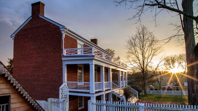 East side of McLean House with both front porches and ice house at sunset