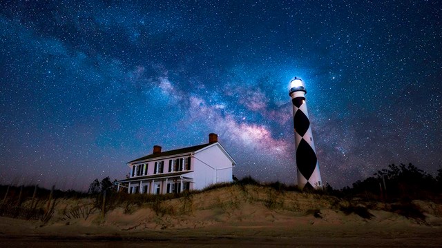 Milky Way arcs over the Cape Lookout Lighthouse and the Keepers' Quarters