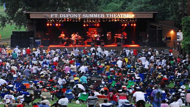 A crowd watches music on stage.