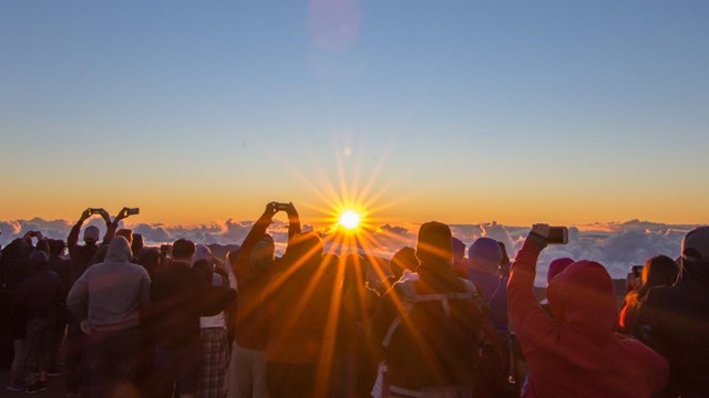 Visitors gather outside the visitor center to watch sunrise.