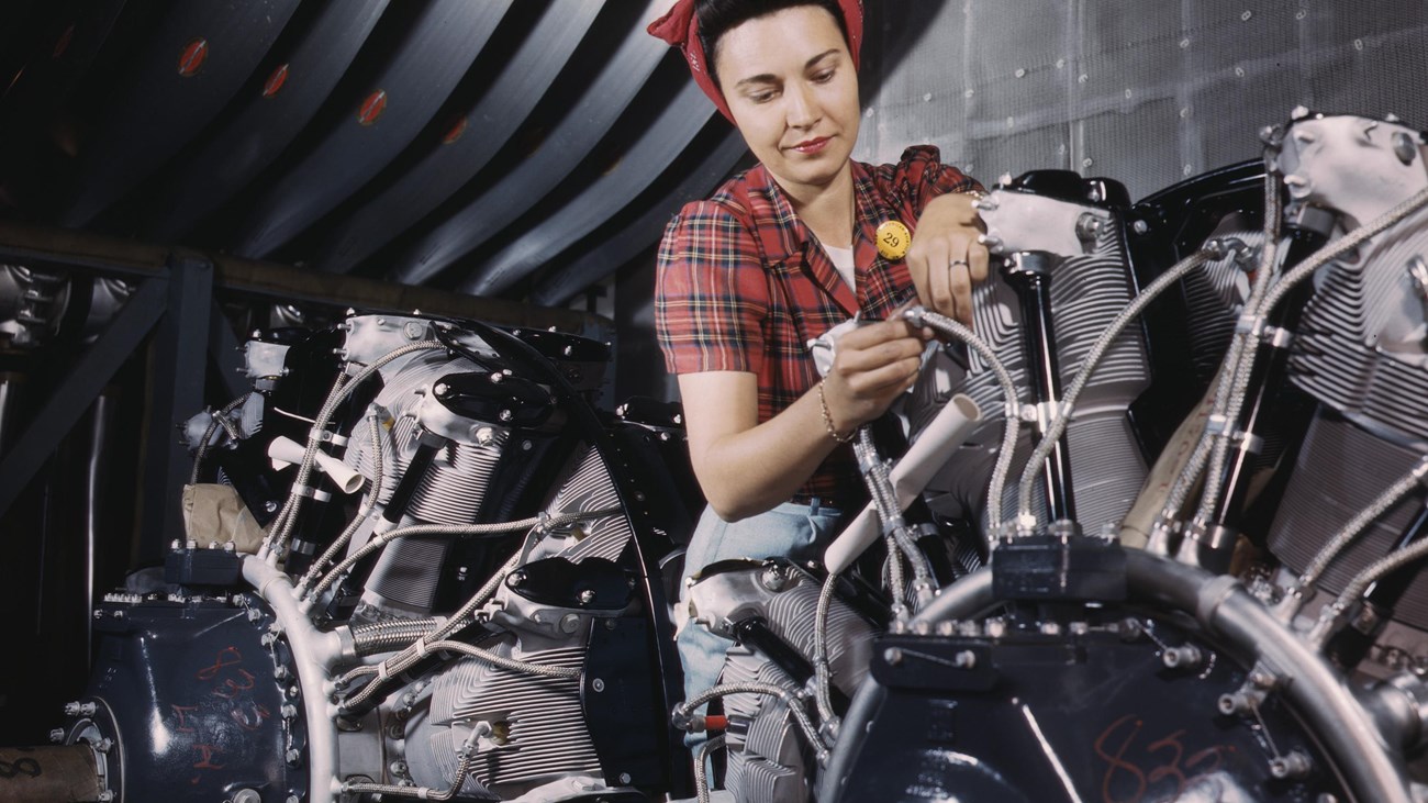 Operating a hand drill at Vultee-Nashville, woman is working on a "Vengeance" dive bomber, Tennessee