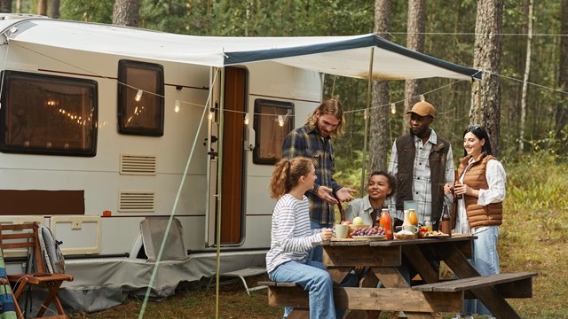 An RV with a group of people enjoying their camping experience.