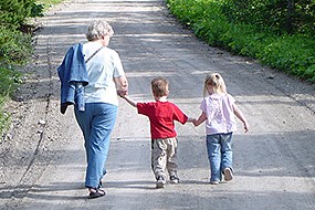 A woman hikes with two little children