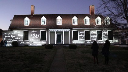 Names of enslaved people projected on a house.