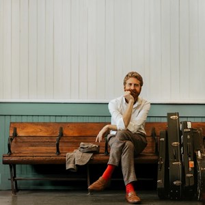 A color photo showing a man with red beard sitting on a courch