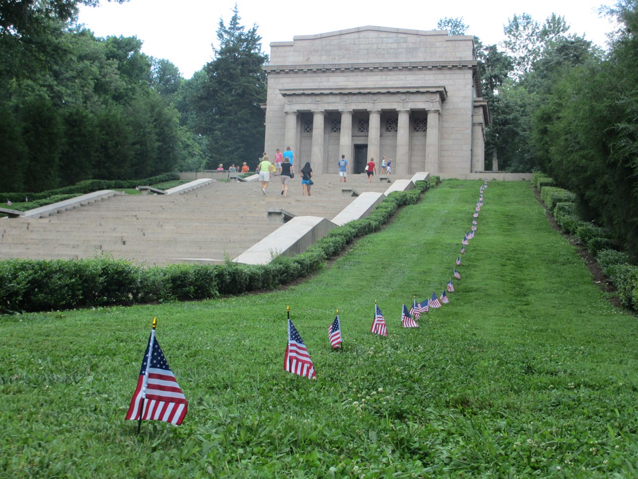 Whtie columned Memorial Building with American Flags