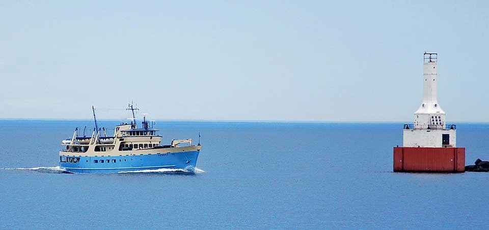 the blue Ranger III ferry boat on left approaching red buoy in right
