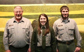 Three park rangers in front of exhibit Three park rangers in front of exhibit