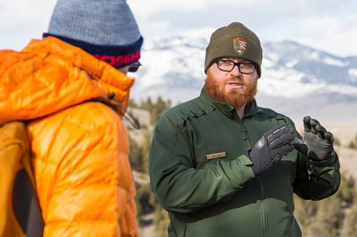 Male park ranger talking to visitor in mountain landscape