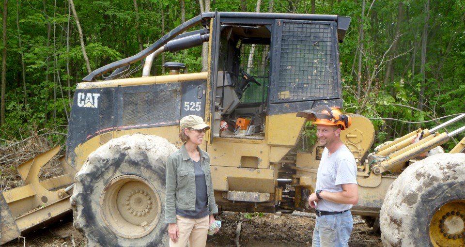 Man and woman talking in front of backhoe