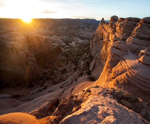 Sunrise from Delicate Arch as the sun rises it begins to illuminate large rock formations