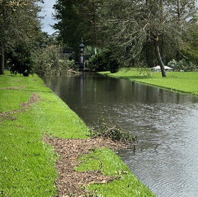 a flooded road leading to a closed gate