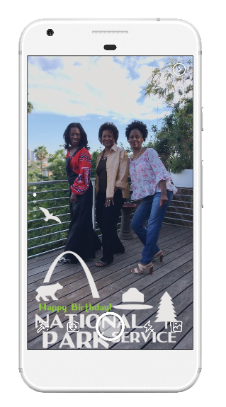 Frame Example a smartphone displays a photo of three women outside with an overlay that says Happy Birthday National Park Service.
