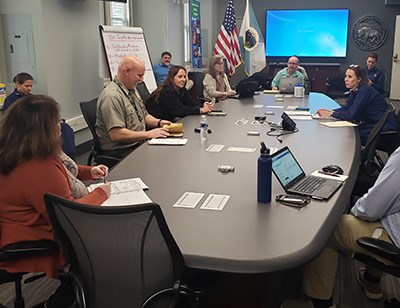 people sitting around a conference table with laptops