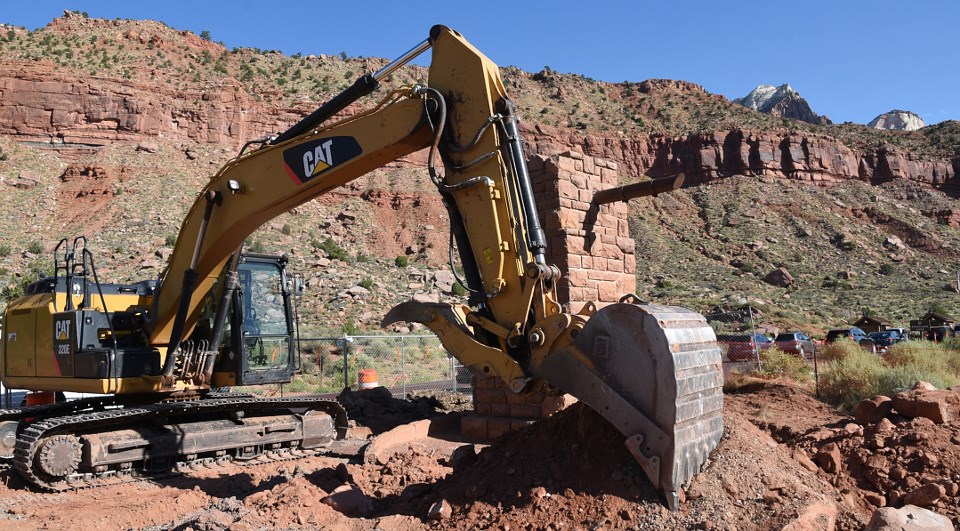 Backhoe digging up ground in national park Backhoe digging up ground in national park