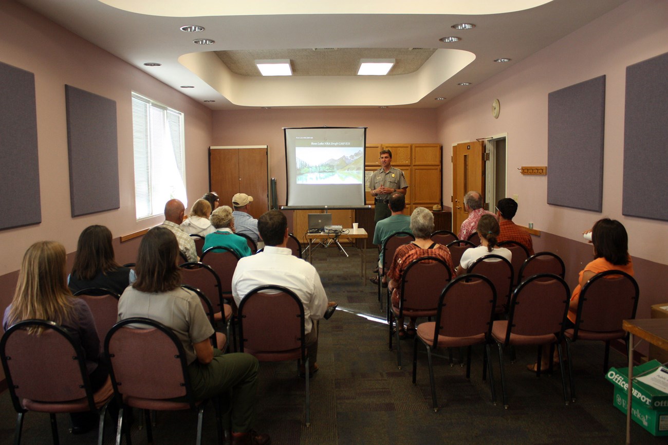 a group meeting with person talking and an audience