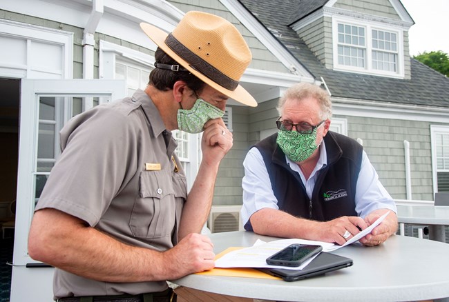 superintendent in uniform talks with friend of acadia member