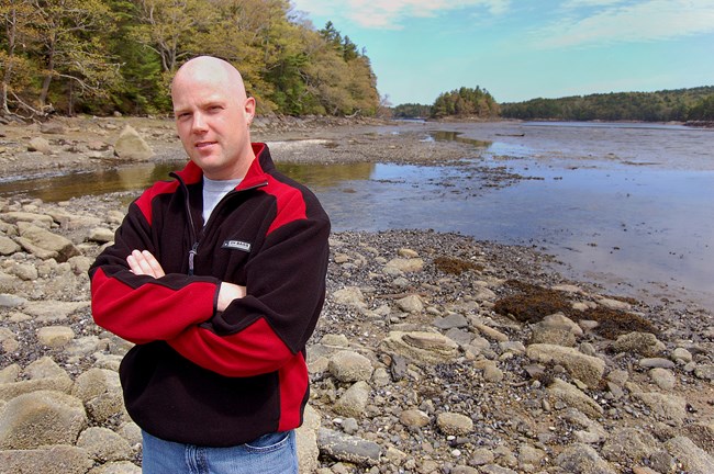 Photo of artist Dan Grenier wish shoreline in the back ground.