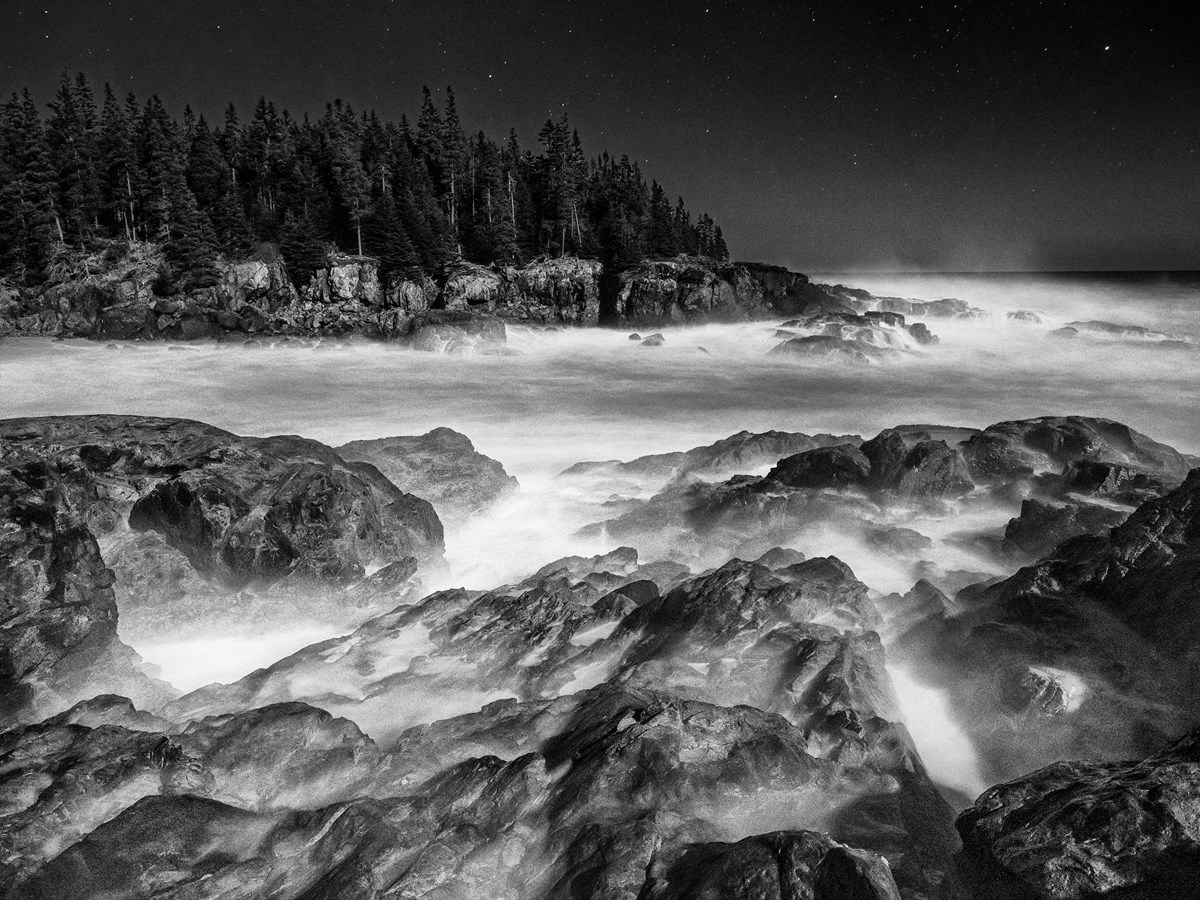 Moon-lit photo of rocky coastline