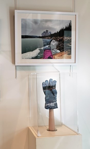 Painted glove in display case below photo of same glove on wall Painted glove in display case below photo of same glove on wall
