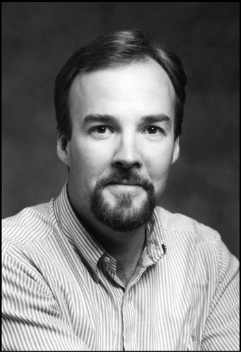 Man with a goatee beard and wearing a striped shirt