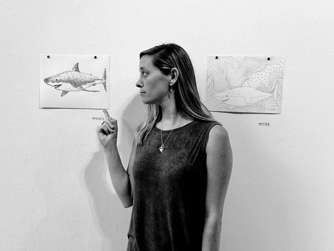 portrait of woman standing by artworks on wall