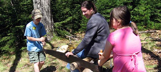 Intern with two kids sawing wood