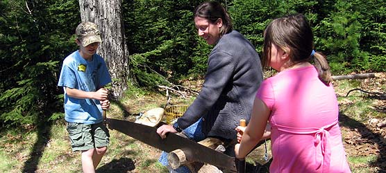 Intern with two kids sawing wood Intern with two kids sawing wood