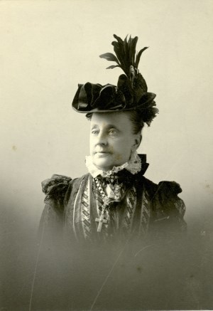 worn picture of an old woman posing in a black hat