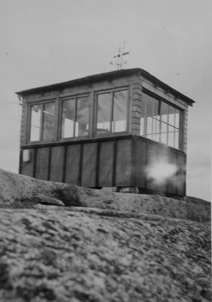 Historic photograph of a fire lookout on a mountain summit