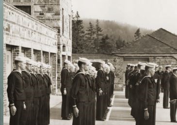 B&W photo of sailors standing at attention in front of a building