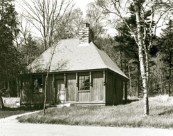 B&W Photo of small wooden sided building with two chimneys