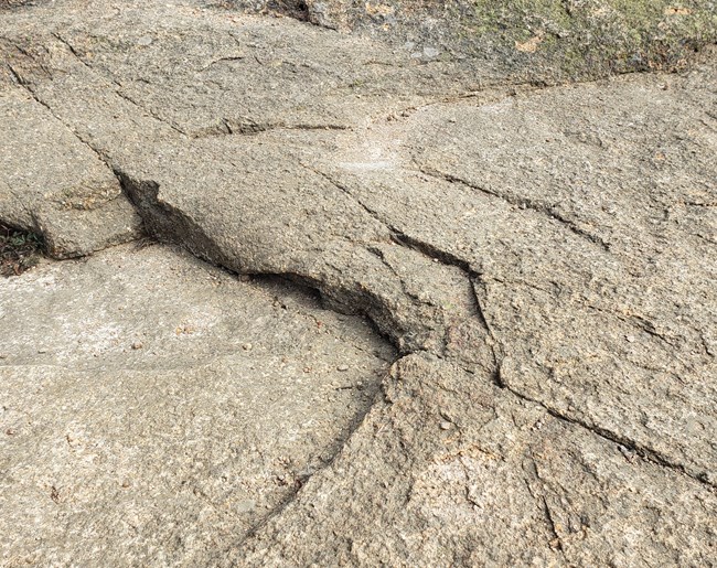 Rock surface is left carved into a crescent shape.
