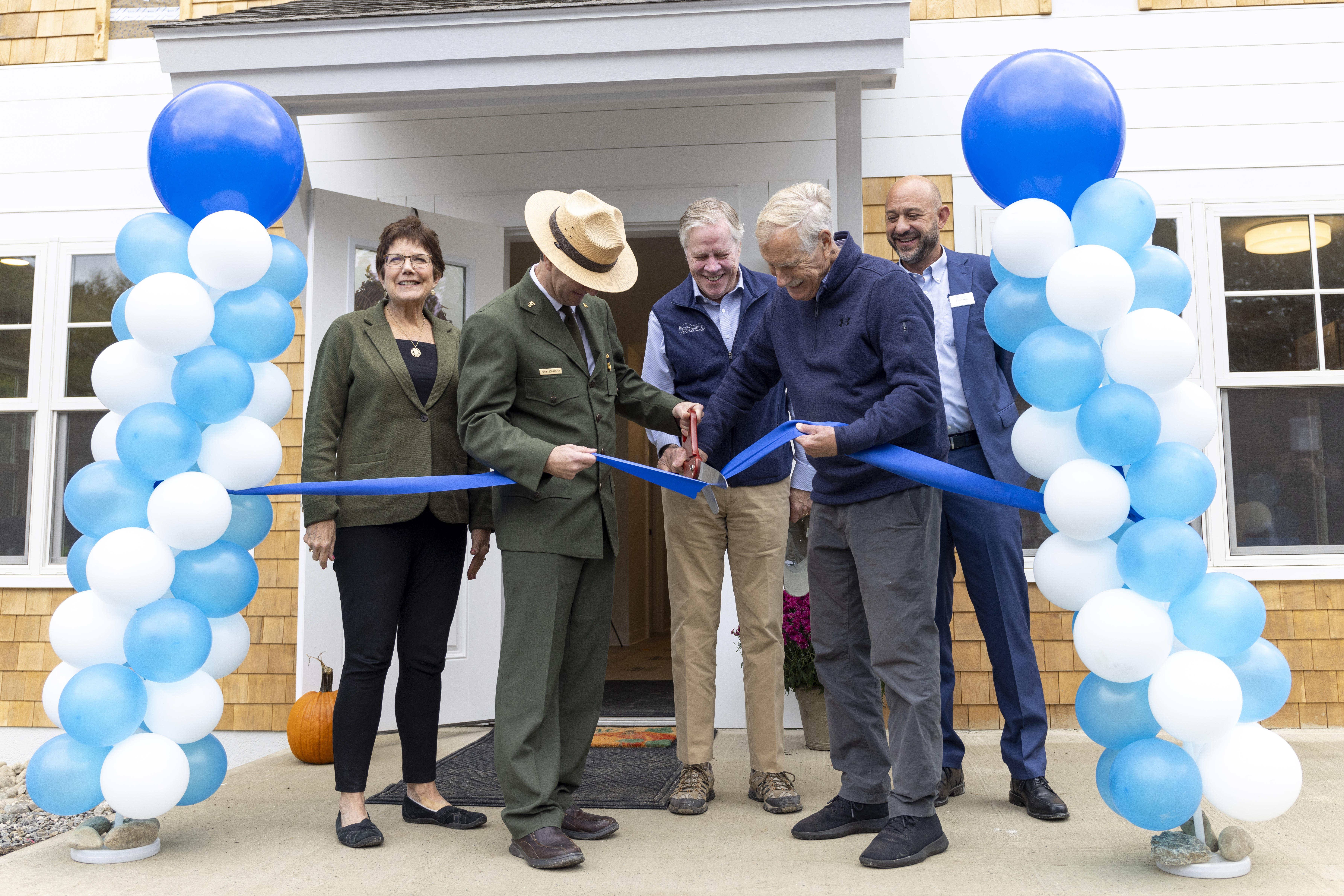 Ribbon Cutting at Dane Farm in Acadia National Park A group of five individuals, one in Ranger uniform, cut the ribbon to new park housing units in Acadia.