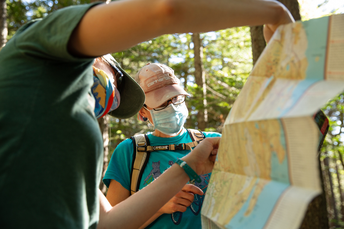 Hikers wearing masks confer over a map