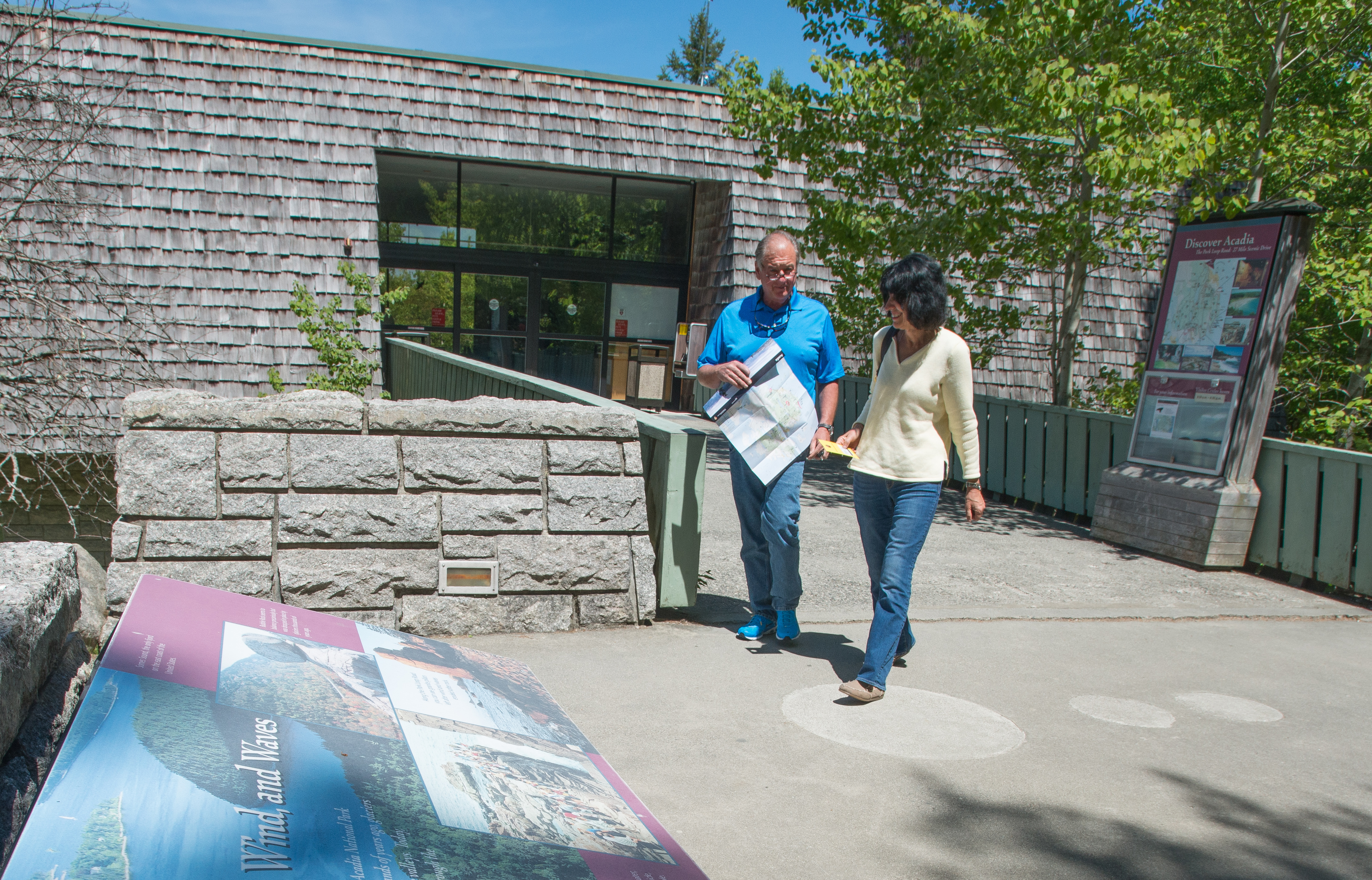 A man and woman walk outside a visitor center entrance