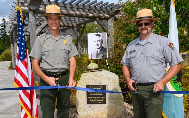 Rangers cut a ribbon in front of stone memorial during dedication ceremony Rangers cut a ribbon in front of stone memorial during dedication ceremony