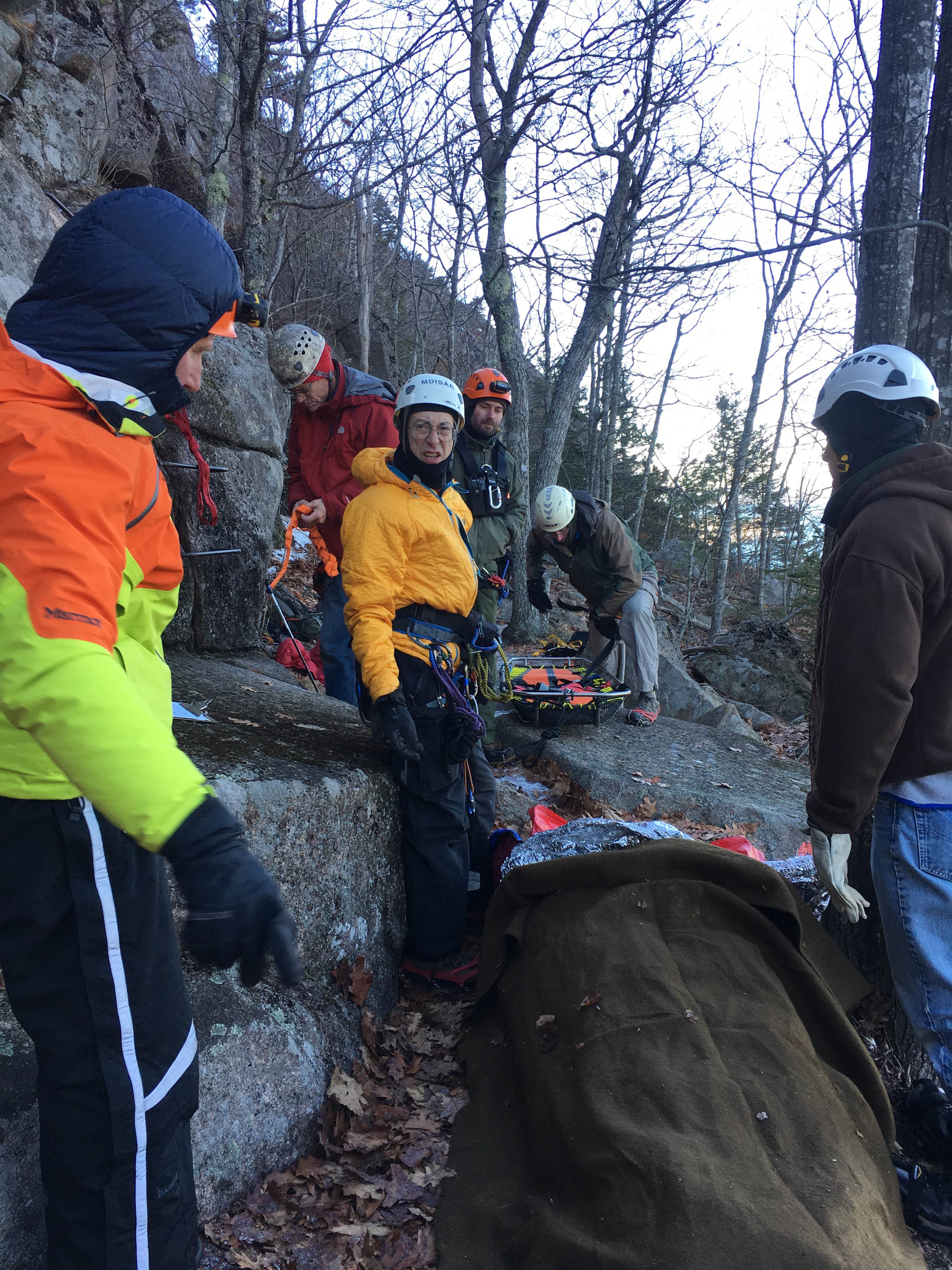 Park rangers and volunteers from Mount Desert Island Search and Rescue prepare to hoist patient by litter to the Maine Army National Guard helicopter.