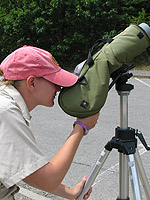 Girl looks through spotting scope