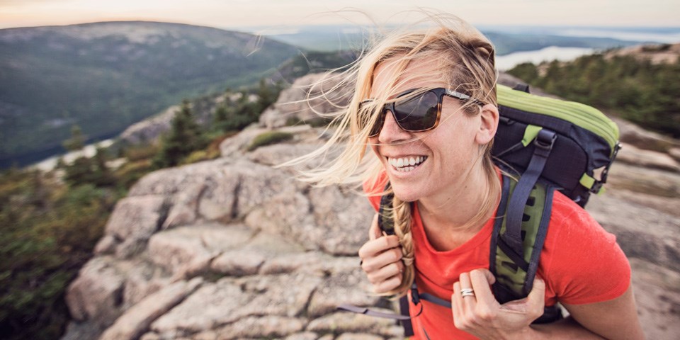 Woman wear packing stands on summit of Pemetic Mountain