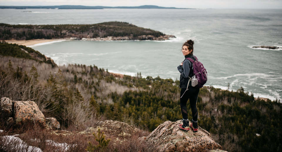 Photo courtesy of Britney Kelley (Used with permission) Woman stands on rock on mountainside overlooking Atlantic coast