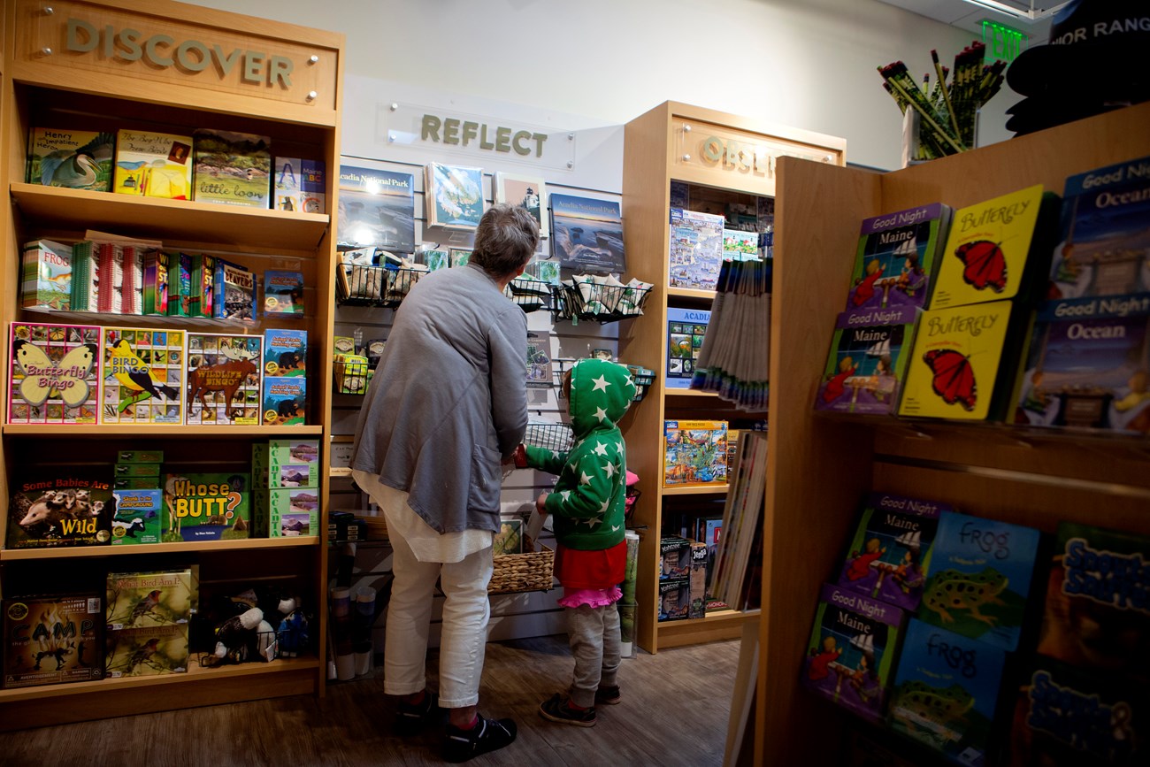 An adult and child looking at books in a store