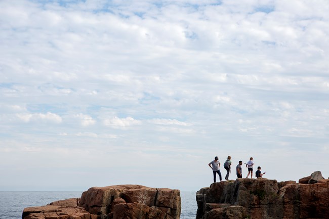 People stand on cliffs by ocean